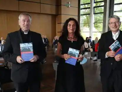 Offizial Weihbischof Wilfried Theising erhielt am Samstag als erster den Kuropka-Erinnerungsband von den Herausgebern Maria Anna Zumholz und Michael Hirschfeld (rechts) &uuml;berreicht.