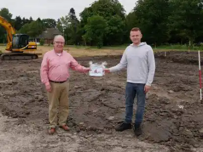 Am 20. Juli begr&uuml;&szlig;te B&uuml;rgermeister Klaus R&uuml;besamen (links) Nils M&uuml;ller als ersten Bauherrn im Baugebiet Schwei mit einem Geschenk.