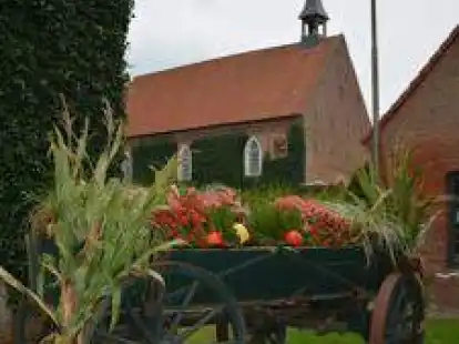 Der mit Erntegaben dekorierte Ackerwagen unterhalb des Glockenturmes der St. Lamberti-Kirche ist ein beliebtes Fotomotiv. Sein kleineres Gegenst&uuml;ck steht am Dorfbrunnen.