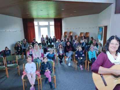 Die Gitarre in der Hand, mehr als 20 Kinder erwartungsvoll vor ihr: Petra Burmester hat ihr musikalisches Projekt in Hinte begonnen.