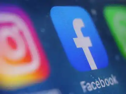 Auf dem Bildschirm eines Smartphones sind die Icons von Instagram, Facebook und WhatsApp zu sehen.