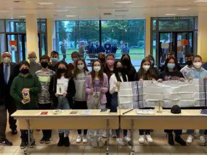 Freuen sich &uuml;ber neue Unterrichtsmaterialien: Schulleiter Jan P&ouml;ssel (1.v.l.), Bodo Gideon Riethm&uuml;ller (2.v.l.), Fachbereichsleiter Christian Langfermann (2.v.r.) und Lehrerin Stephanie Schoe (1.v.r.) mit ihrem Religionskurs aus der 8. Klasse