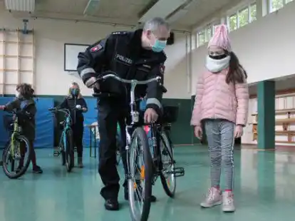 So sieht ein sicheres Fahrrad aus: Polizist Bernd Rudolphi mit einer Viertkl&auml;sslerin der Grundschule Neerstedt.