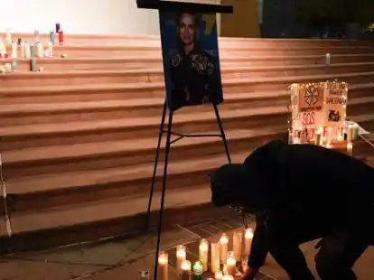 Ein Mann stellt eine Kerze w&auml;hrend einer Mahnwache in Gedenken an die verstorbene Kamerafrau Halyna Hutchins auf.