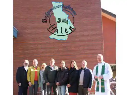 Sie pr&auml;sentierten das von Simone Krieger und Kay Kannwischer (3. und 4. von rechts) gestaltete Namenslogo des Dorfgemeinschaftshauses Halen: Pfarrer Ludger Jonas (von rechts), Josef Wedemeyer, Jens Bockhorst und Maria Heller vom Kirchenausschuss sowie Sponsor Ludger Wedemeyer und  Kirchenprovisor Heinz Prenger.
