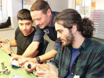 Gesch&auml;ftsf&uuml;hrer Thomas Maur (Mitte) zeigt Josep Alfonso Peinado (links) und Jan Ricard Nugu&eacute; Marques (rechts) bei der Ausmodellierung einer Zahnprothese noch einen Handkniff.