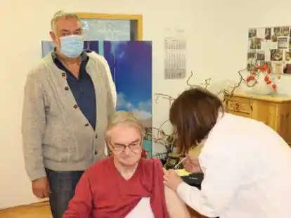 Bewohner Friedel Naber (sitzend) erh&auml;lt von Judith Niester seine Auffrischimpfung. Einrichtungsleiter Hermann Dirks (stehend) freut sich &uuml;ber die Impfbereitschaft im Kreisaltenheim.