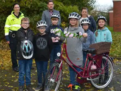 Freuen sich &uuml;ber ihre neuen Fahrradhelme: (vorne von links) Ben, Tobe, Gesa, Johanna, Leon und Alexandra aus der 3a und 3b der Grundschule Hohenkirchen, mit (hinten von links) der Pr&auml;ventionsbeauftragten der Polizeiinspektion Wilhelmshaven/Friesland Tanja Horst, Jan-Simon Otten von der Verkehrswacht und der kommissarischen Schulleiterin Johanna Donker