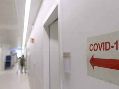 Ein Schild mit der Aufschrift &bdquo;Covid-19&ldquo; und einem Pfeil verweist auf die Corona-Intensivstation.