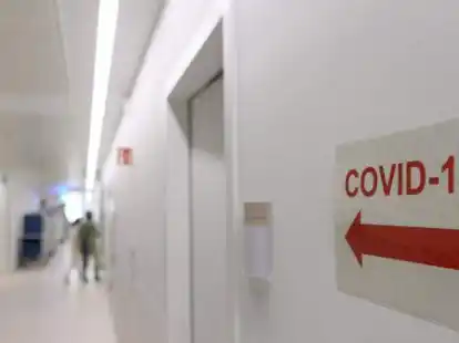 Ein Schild mit der Aufschrift &bdquo;Covid-19&ldquo; und einem Pfeil verweist auf die Corona-Intensivstation.