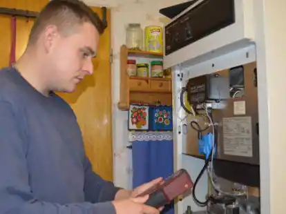 EWE-Kundendienstmitarbeiter David Block gibt Entwarnung: Bei dieser Heizungsanlage ist die Umstellung kein Problem. Coronabedingt tragen die Mitarbeiter eine Schutzmaske beim Kundenbesuch, die Block nur f&uuml;r das Foto kurz abgenommen hat.