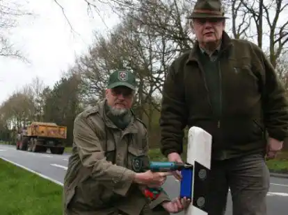 Durch Anbringung von Wildwarnreflektoren wie hier in Harkebr&uuml;gge durch die J&auml;ger Heinz Hinderks (links) und Rudolf Schulte versuchen auch die J&auml;ger zur Vermeidung von Wildunf&auml;llen beizutragen.