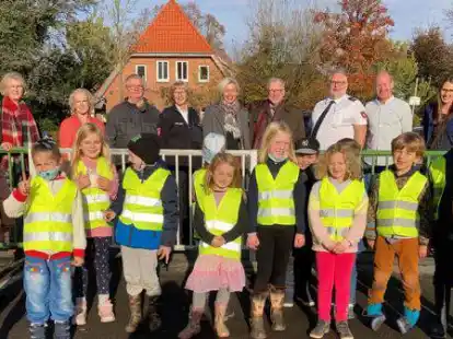 In knalligen Farben sind sie gut zu sehen: Die Erstkl&auml;ssler der Grundschule Rostrup tragen die neuen Warnwesten, dahinter stehen (v.li.) Klassenlehrerin Elke Nodop, Ingrid Meiners vom Landkreis, Kreisverkehrswachts-Gesch&auml;ftsf&uuml;hrer Hermann Nee, Verkehrssicherheitsberaterin Helga Behrmann, Landr&auml;tin Karin Harms, Polizeipr&auml;sident Johann K&uuml;hme, Kreisverkehrswachts-Vorsitzender Klaus Blaser, Schulleiter Patrick Wulf und Schulleiterin Ann-Charlott Meinen.