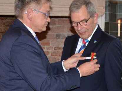 Die h&ouml;chste Auszeichnung der Bundesrepublik Deutschland wird nur wenigen zuteil: Landrat Olaf Meinen (links) hat die Ehre Dr. J&ouml;rg Hagena aus Norden das Bundesverdienstkreuz zu &uuml;berreichen beziehungsweise anzuheften.