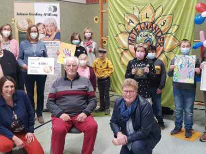 Freude bei allen Beteiligten: Sch&uuml;ler aus diesem und dem vergangenen AG-Jahr sind stolz auf den F&ouml;rderpreis. Mit ihnen freuen sich (hi. v.l.) Helge Kahnert, Vorsitzende des Edewechter Seniorenbeirats, Schulleiterin Susanne Behrens, Karin Hoyer, p&auml;daogische Fachkraft, Celia Hobl, B&uuml;nting Stiftung, Lehrerin Silke Sch&uuml;tz, (vo. v.l.) Petra Meilahn, Seniorenzentrum Adewacht, Bewohner Siegfried Dr&ouml;ge, und Edewechts B&uuml;rgermeisterin Petra Knetemann.