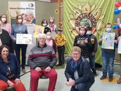 Freude bei allen Beteiligten: Sch&uuml;ler aus diesem und dem vergangenen AG-Jahr sind stolz auf den F&ouml;rderpreis. Mit ihnen freuen sich (hi. v.l.) Helge Kahnert, Vorsitzende des Edewechter Seniorenbeirats, Schulleiterin Susanne Behrens, Karin Hoyer, p&auml;daogische Fachkraft, Celia Hobl, B&uuml;nting Stiftung, Lehrerin Silke Sch&uuml;tz, (vo. v.l.) Petra Meilahn, Seniorenzentrum Adewacht, Bewohner Siegfried Dr&ouml;ge, und Edewechts B&uuml;rgermeisterin Petra Knetemann.