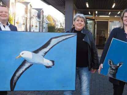 Christian G&ouml;rres, Dagmar Morgenstern und Melanie Gloystein (von links) pr&auml;sentieren zwei Werke, die in der Filiale auch zu sehen sind.
