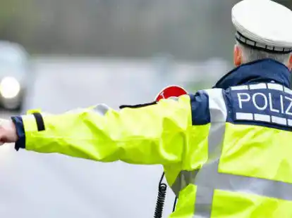 Ein Polizist h&auml;lt bei einer Geschwindigkeitskontrolle Fahrzeuge an.