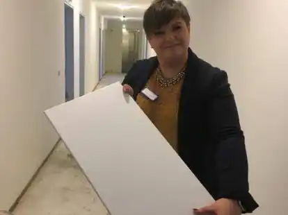 Auf der Baustelle im ersten Stock: Raisa Bechtold zeigt die neuen Fliesen f&uuml;r die B&auml;der.