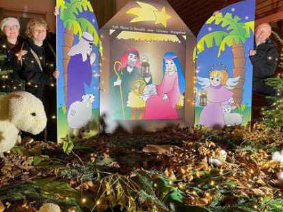 Die Schwestern Marie und Anna-Lena von Somnitz pr&auml;sentieren mit Pfarrer Walter Albers die Krippe im Fenster des Gemeindehauses am Karlshof.