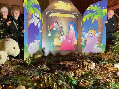 Die Schwestern Marie und Anna-Lena von Somnitz pr&auml;sentieren mit Pfarrer Walter Albers die Krippe im Fenster des Gemeindehauses am Karlshof.