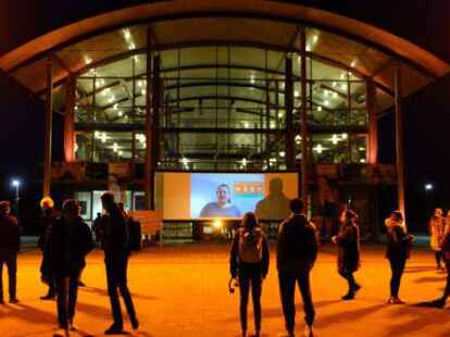 Die Blicke sind auf die Leinwand gerichtet: Am &bdquo;Orange Day&ldquo; spielten Studierende der Hochschule Emden/Leer ihre selbst gedrehten Videoclips auf dem Campus ab.
