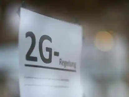 Auf einem Schild an der T&uuml;r eines Gesch&auml;fts wird auf die 2G-Regel hingewiesen.