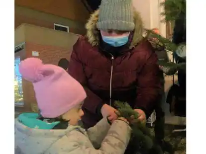 Lena ist begeistert von den bunten Kugeln. Mutter Nadine Czermark hilft ihr beim Befestigen.