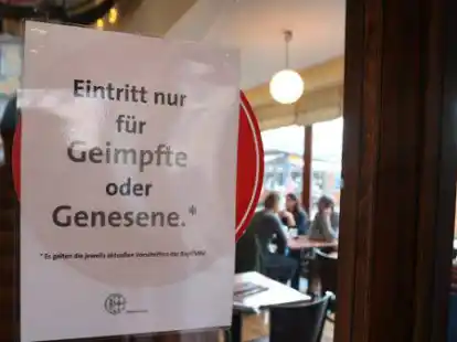 Am Eingang eines Caf&eacute;s wird die Einhaltung der 2G-Regel hingewiesen.