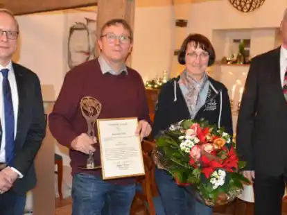 Ratsvorsitzender Dirk Rode-B&ouml;ckmann (links) und B&uuml;rgermeister Michael Kramer (rechts) &uuml;berreichten den Sozialpreis an Josef Lamping und einen Blumenstrau&szlig; an Ehefrau Christa.