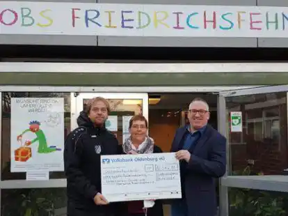 Schulleiter Holger J&auml;ckel (rechts) und Lehrer Elmar Schreiber, Organisator des Sponsorenlaufs, &uuml;bergaben den symbolischen Scheck &uuml;ber 16342 Euro an Petra Reiners, 1. Vorsitzende des F&ouml;rdervereins der Grund- und Oberschule Friedrichsfehn (Mitte).