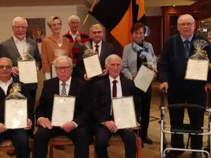 Vorsitzender Heinrich Wienken (stehend, l.) und zweiter Vorsitzender Hubert Bley (stehend, r.) gratulierten den anwesenden Jubilaren (v.l.) Kurt Kallage, Ina Hinxlage, Manfred Tapken, Waltraud Meyer, Hans Vornhagen sowie (sitzend von links) Hugo H&ouml;gemann, Bernhard Tebben und Hans L&uuml;ken.