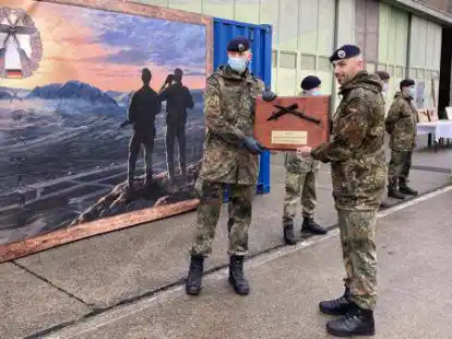 Hauptgefreiter Jonathan Leendertz (links) bekommt von Oberst Marc Vogt den Wanderpokal &uuml;berreicht.