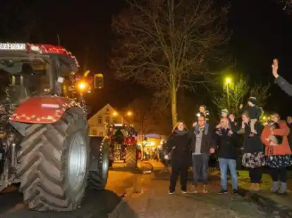 Ein besonderer Adventsumzug: Wiebke (36) Sebastian (35) mit Hauke (2) Carsten (33) mit Tabea (2) Annika (30) mit Mats (2) Janina (31) mit Jack Russel Balou (4)  bewundern den Adventsumzug der Aper Landwirte mit ihren bunten Treckern.