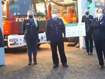 Vertreter der Jugendwehren pr&auml;sentieren den Scheck von der Firma Schr&ouml;der aus Schweiburg, den Lena de Wit &uuml;berreicht hat.