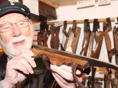 Museumsleiter Albert Janssen mit einem alten Langlooper, einem Sch&ouml;fel, geschmiedet aus Eisen und verkleidet mit Holz, irgendwo aus einem kleinen Betrieb in Ostfriesland.