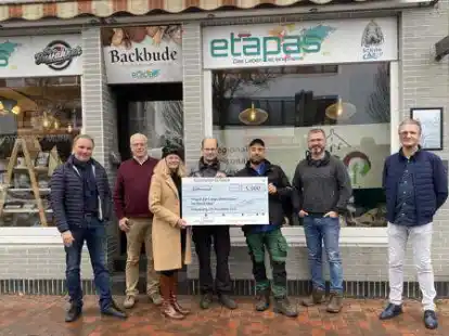 Gl&uuml;cklich halten Teilnehmer  vom Rohdenhof den Spendencheck: (von links) Normen Strecker, Erwin B&ouml;ning, Alexandra Strecker, Bernd Wachsmann, Andreas Greven, Yasar Balkanci-von H&auml;fen und Kai van R&uuml;schen (Produktionsleiter Nova H&uuml;ppe).