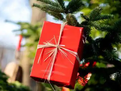 Ein Geschenk h&auml;ngt an einem Tannenbaum.