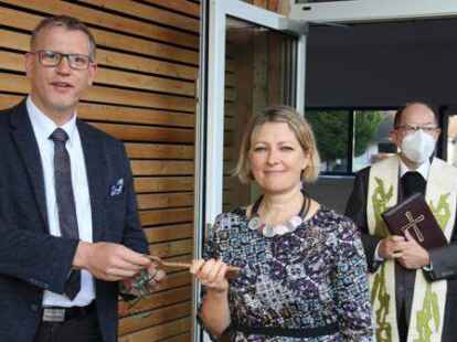 B&uuml;rgermeister Jens Kuraschinski &uuml;bergibt Rektorin Elena Lietzmann den Schl&uuml;ssel f&uuml;r die &bdquo;neue&ldquo; Sankt-Peter-Schule. Rechts Pfarrer Ludger Brock.