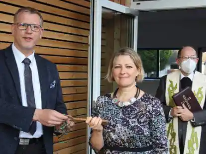 B&uuml;rgermeister Jens Kuraschinski &uuml;bergibt Rektorin Elena Lietzmann den Schl&uuml;ssel f&uuml;r die &bdquo;neue&ldquo; Sankt-Peter-Schule. Rechts Pfarrer Ludger Brock.