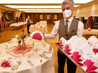 Im &bdquo;Airfield Hotel & Restaurant&ldquo; deckt Stefan Kleine (rechts) den gro&szlig;en Saal f&uuml;r das Gala-B&uuml;fett ein.