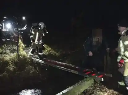 Rettungseinsatz in der Dunkelheit: Die Feuerwehr legte eine Leiter &uuml;ber den mit Wasser vollgelaufenen Graben.