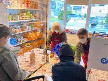 Lebensmittelausgabe beim Hatter B&uuml;fett: Die von der Decke h&auml;ngende Scheibe soll die Ansteckungsgefahr verringern.