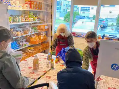 Lebensmittelausgabe beim Hatter B&uuml;fett: Die von der Decke h&auml;ngende Scheibe soll die Ansteckungsgefahr verringern.