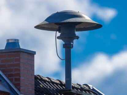 Eine Alarmsirene steht auf einem Hausdach.