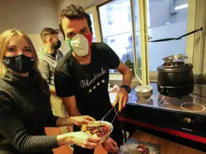 Hilfsbereit: Valeska K&auml;mpfer und Daniel Gargiulo hier bei der Essens-Ausgabe am Fenster des &bdquo;Caf&eacute; Caro&ldquo; an der Heiligengeiststra&szlig;e 19.
