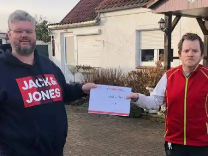 Der Vorsitzende des Handels- und Gewerbeverein (HGV) Bar&szlig;el Michael Niemeyer (links) &uuml;berreichte den ersten Preis der Weihnachtsverlosung an den Gewinner Matthias Trzaskaz.