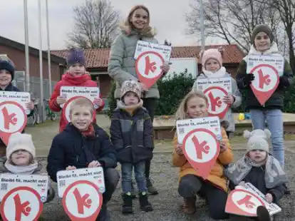 Pr&auml;sentieren die Schilder der neuen Bewegungshaltestellen: M&auml;dchen und Jungen vom Kinderturnen mit ihren Geschwistern.