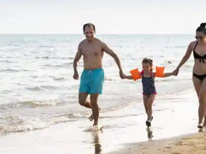 Eine Familie im Sommerurlaub am Strand &ndash; viele planen in diesen Winter-Tagen die sch&ouml;nsten Tage des Jahres.