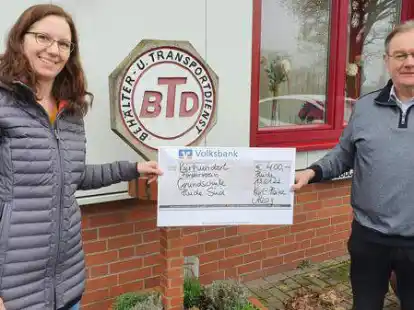 Jedes Jahr schreddert Karl-Heinz Alzog (rechts) in Hude die Tannenb&auml;ume gegen eine Spende der B&uuml;rgerinnen und B&uuml;rger f&uuml;r den guten Zweck. Dieses Mal kamen 400 Euro zusammen, die Marlies Schr&ouml;der vom F&ouml;rderverein der Grundschule S&uuml;d entgegennahm.